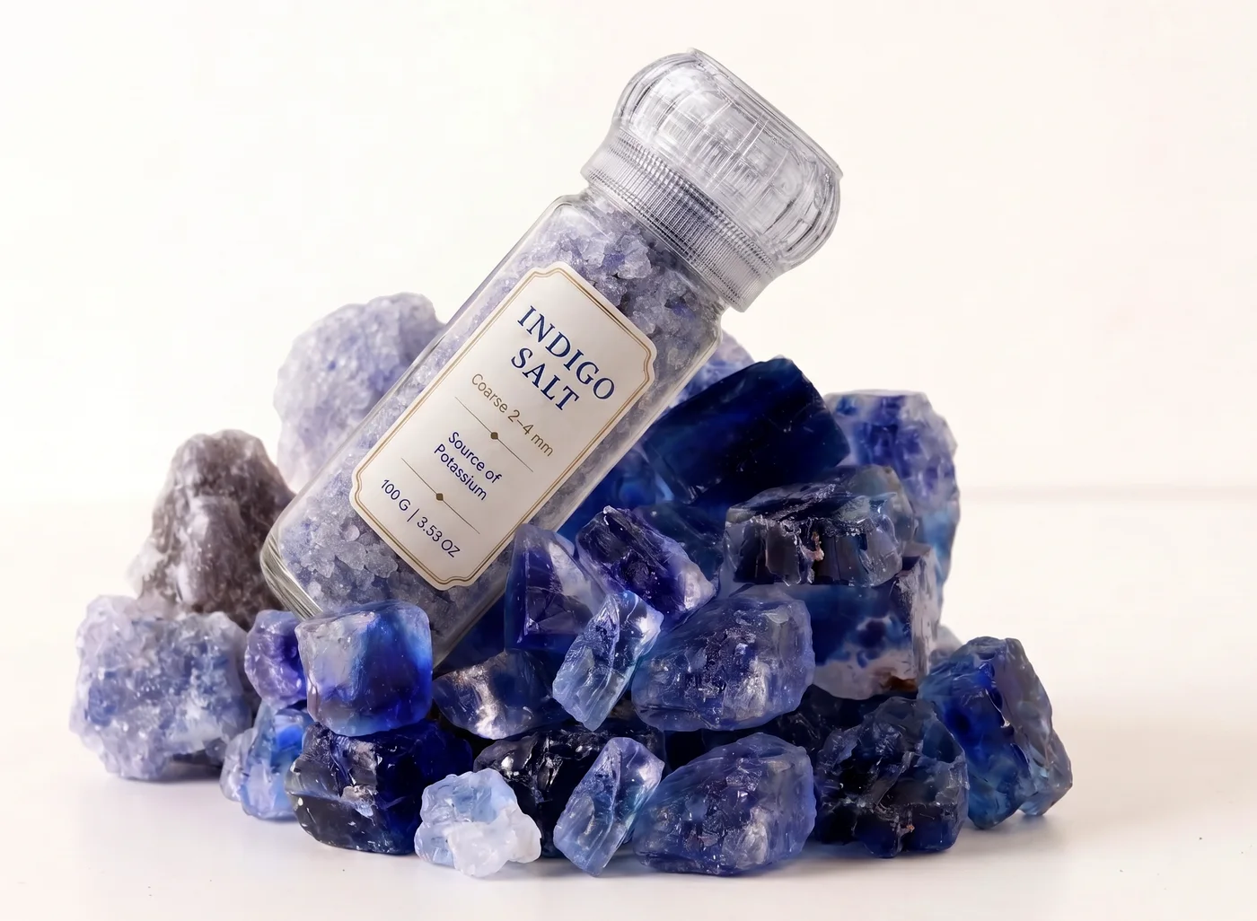 Indigo Salt grinder resting on a pile of raw indigo crystals